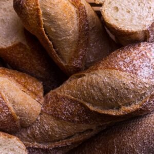 Uma alternativa para a diminuição do consumo de pão francês é trocá-lo por pão integral. A imagem mostra pães integrais em formato semelhante ao do pão francês ou pão branco.