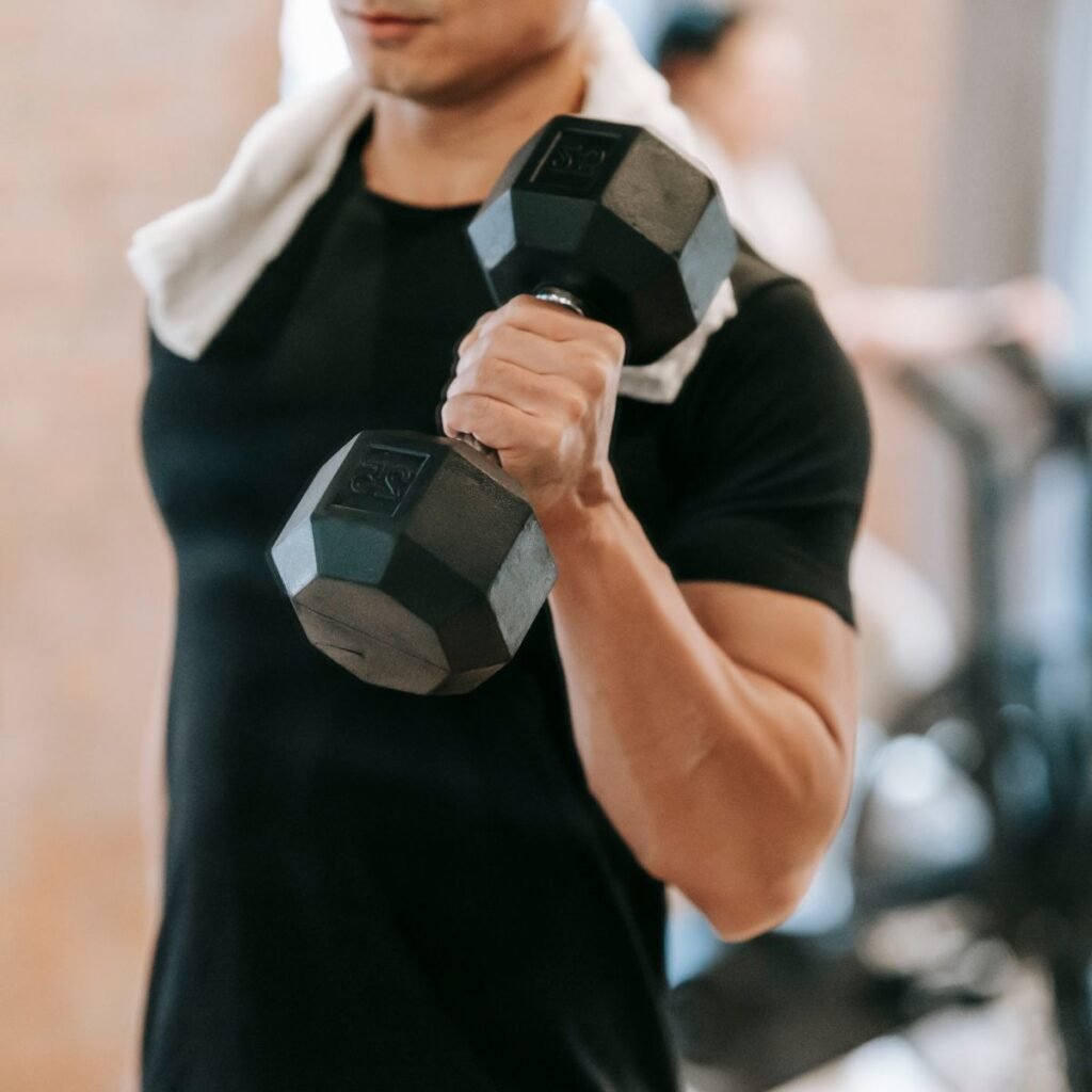 Como ganhar massa muscular. A imagem mostra um homem malhando com halteres.