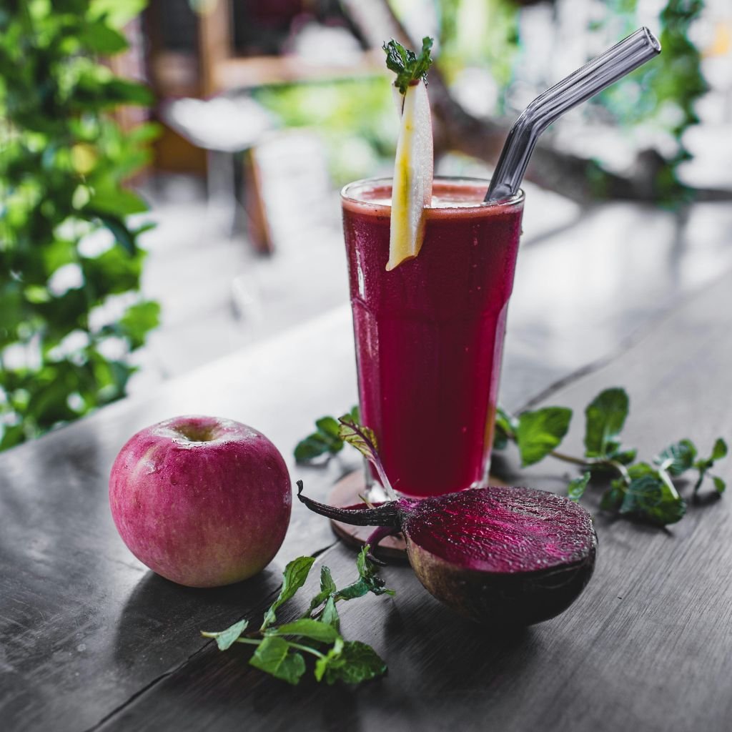 A imagem mostra um belo suco de beterraba sobre uma mesa.