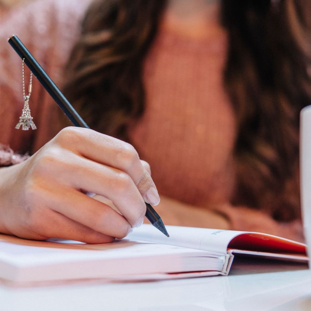 Mulher escrevendo, uma forma de diminuir a ansiedade diária.
